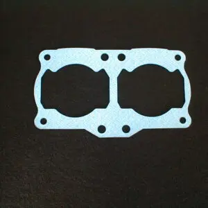 A blue gasket on a black surface, specifically the 1 Piece RZ 350/Banshee base gasket with part number 15-5701.