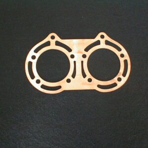 A Copper Head Gasket on a black surface, perfect for Yamaha Banshee.