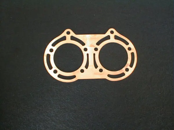 A Copper Head Gasket on a black surface, perfect for Yamaha Banshee.