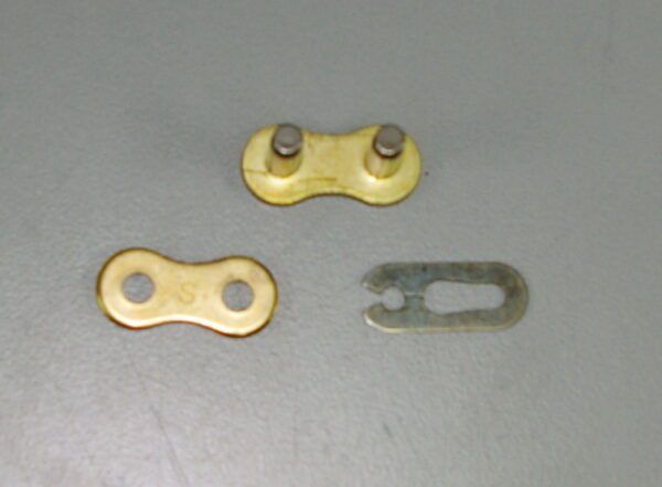 A pair of EK MASTER LINK MRD7 520 chain links and a nut, Part# 18-5926.