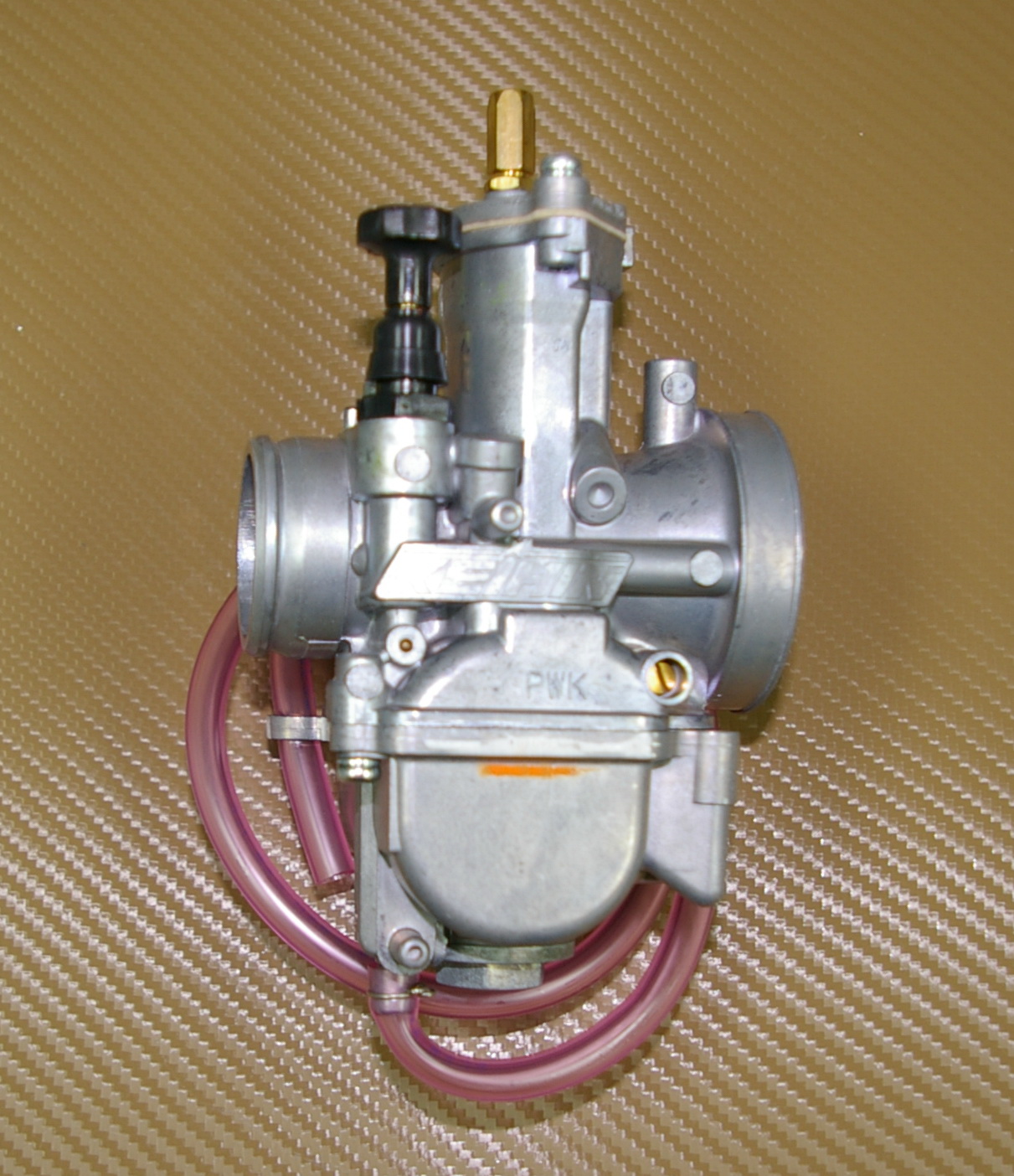 An image of a 28mm PWK Keihin Carburetor Kit, Part 22-5841 with a pink hose.