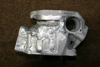 An image of a silver cylinder head on a carpet.