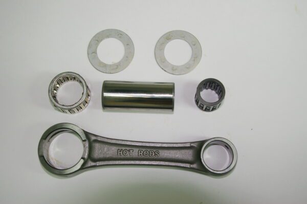 A set of metal parts including a sprocket and HOT RODS Connecting Rod Stock 110mm length, Part# 91-5715.