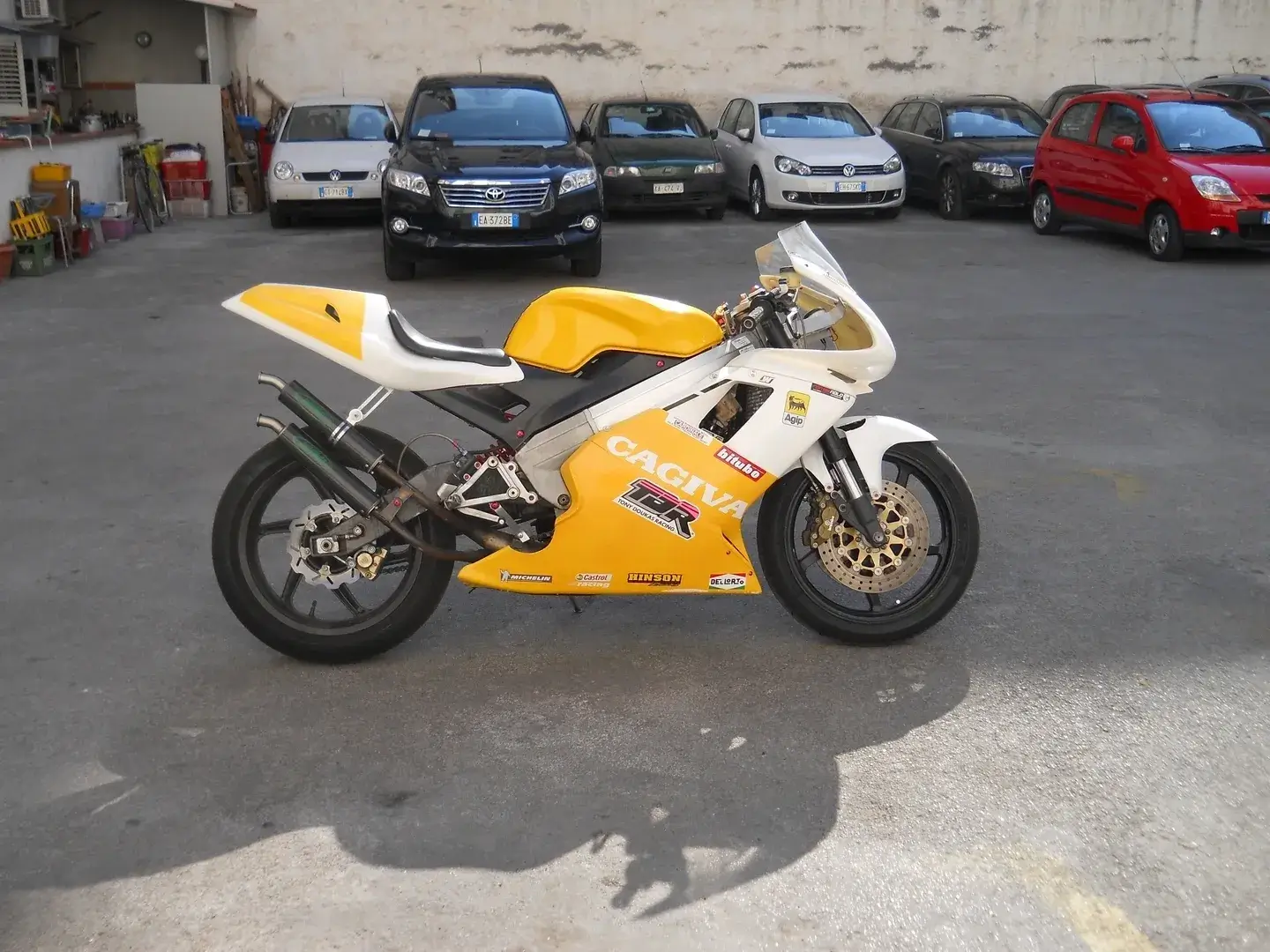 A yellow and white motorcycle parked in the parking lot.