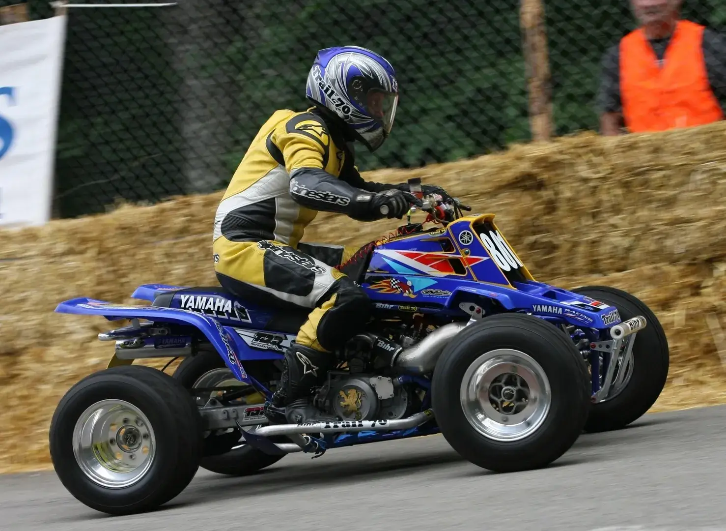 A person on a blue and yellow atv.