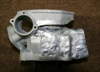 An image of an engine block with a piece of metal on it.
